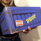 A woman holds a blue Secretlab box.